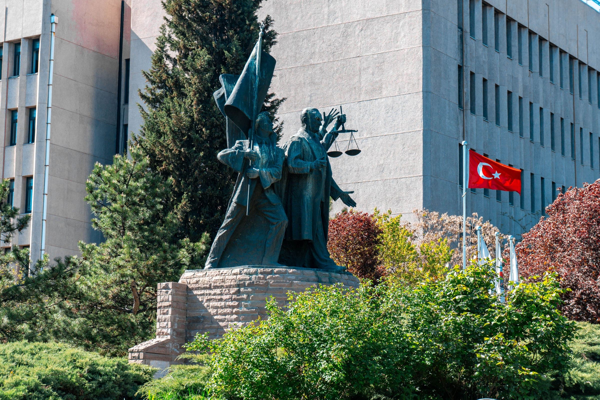 Une statue et un drapeau turc devant un bâtiment officiel