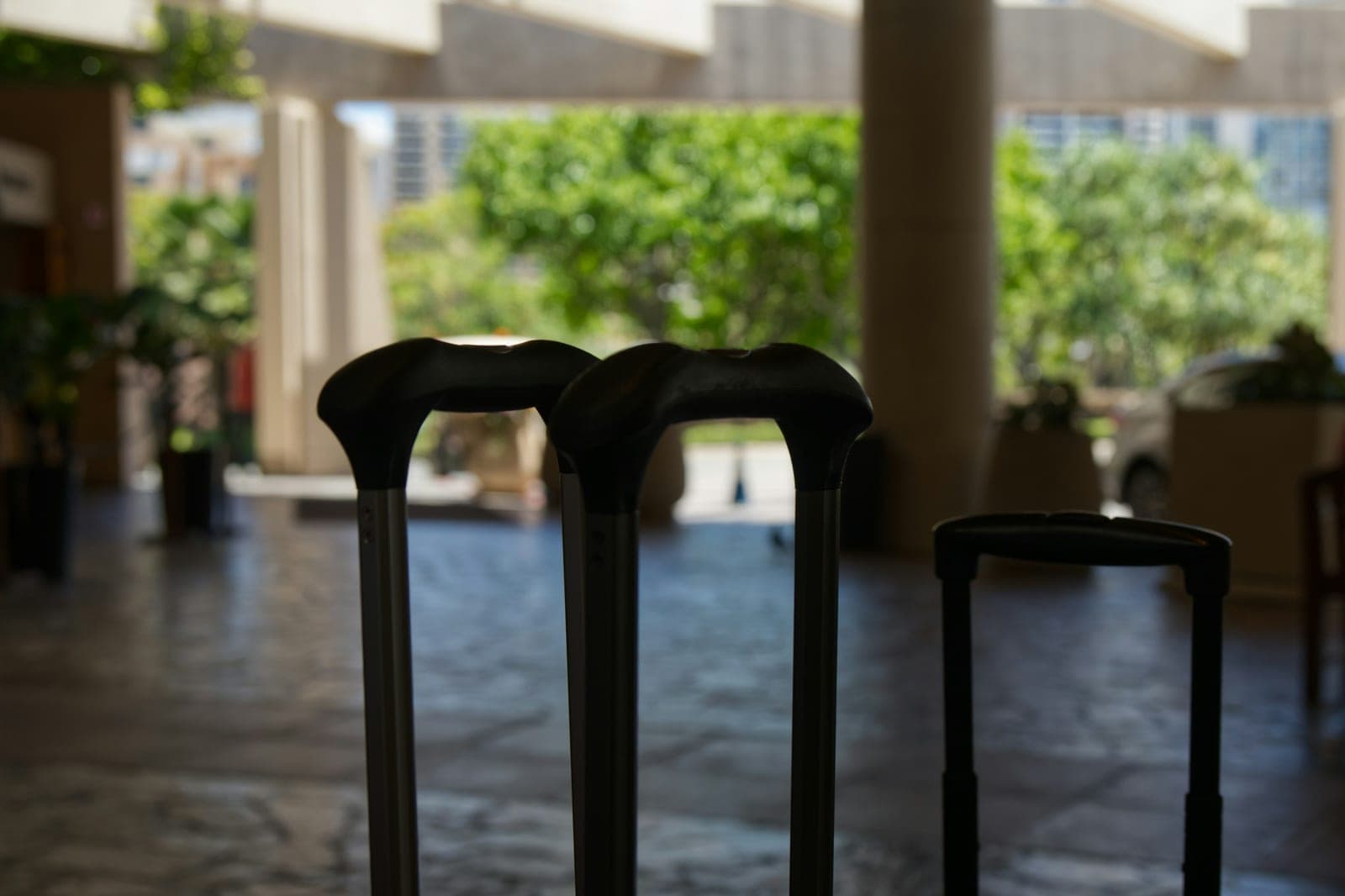 Les poignées télescopiques de valises posées dans un hall
