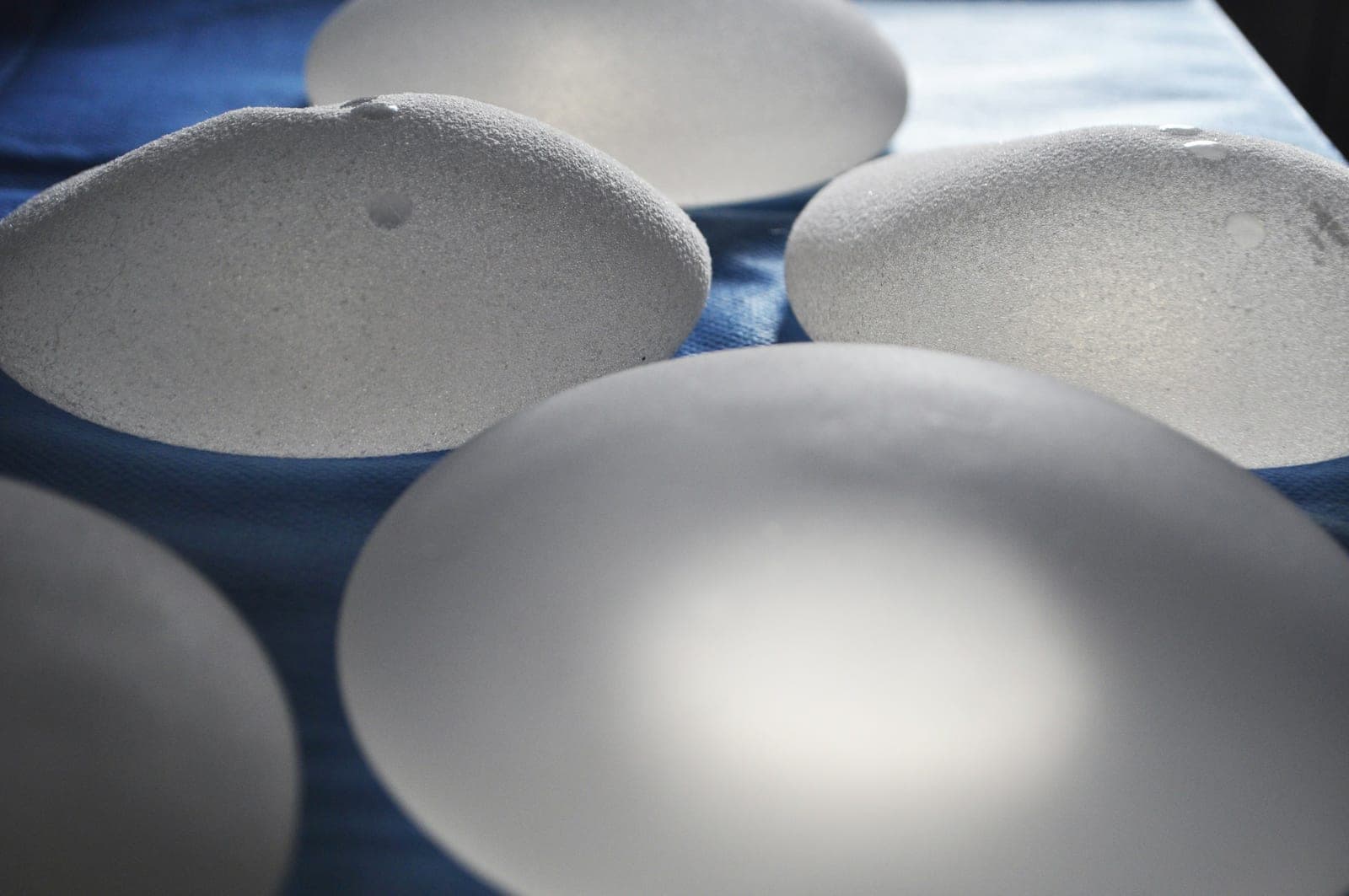 Des implants mammaires texturés sur un champ opératoire bleu