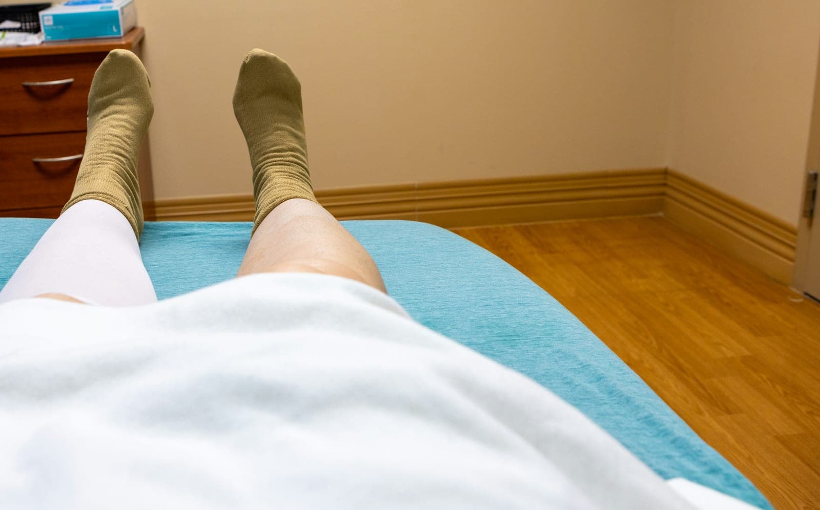 Beine und Füße in Socken einer Person, die auf einer Untersuchungsliege liegt